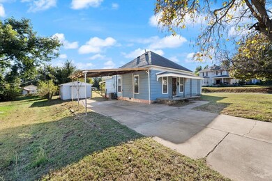 View of home's exterior with a lawn, a carport, driveway, and a shingled roof