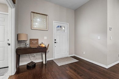 Foyer featuring dark wood finished floors and baseboards