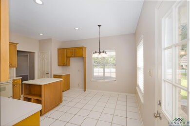 Kitchen featuring a chandelier, light countertops, hanging light fixtures, brown cabinetry, and recessed lighting