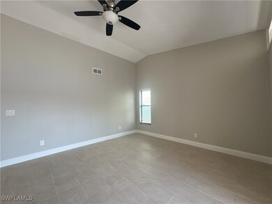 Spare room featuring lofted ceiling and ceiling fa