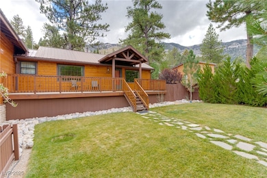 View of front of property with stairway, a deck with mountain view, a front yard, and a metal roof