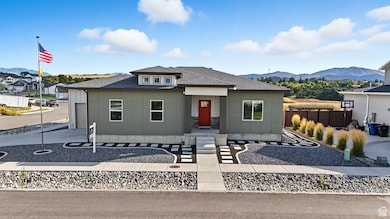 View of front of home featuring roof with shingles, a mountain view, board and batten siding, and driveway