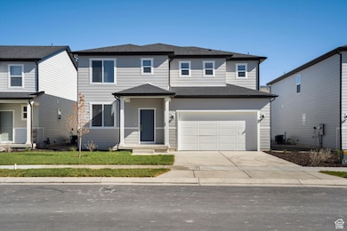 Traditional home featuring concrete driveway, a shingled roof, an attached garage, and covered porch