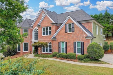View of front of home featuring brick siding, a front yard, and a shingled roof