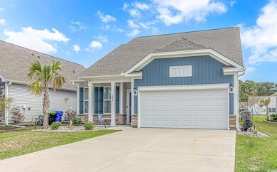 View of front of house with stone siding, driveway
