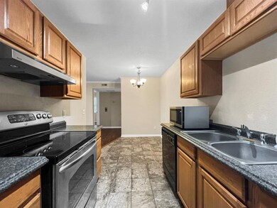 Kitchen with  light tile floors, sink, and appliances with stainless steel finishes