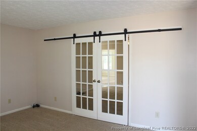 Formal living opens to family room when sliding open these interior barn doors.