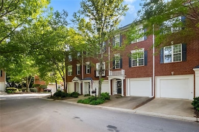 Townhome / multi-family property featuring driveway, an attached garage, and brick siding