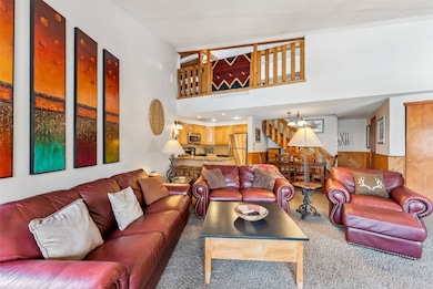 Carpeted living area with a chandelier, wood walls