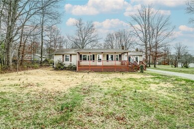 Single story home featuring a wooden deck and a front yard