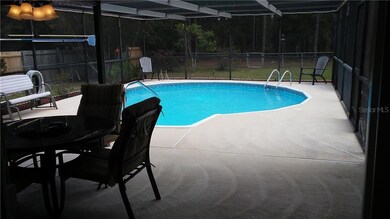 LOOKING OUT FROM LIVING ROOM 24X12 COVERED PORCH ON 27X24 SCREENED POOL AREA, CONSERVATION AREA ADJOINS REAR OF PROPERTY