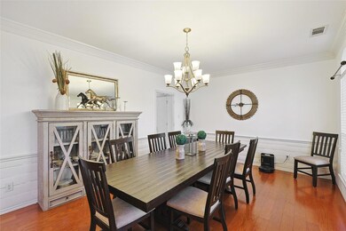 Dining area with a chandelier, crown molding, and dark hardwood / wood-style floors