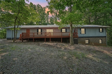 View of front facade featuring a wooden deck, cooling unit, and brick siding