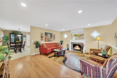 Formal Living Room with Granite Fireplace, Engineered Wood Flooring, & Recessed Lighting - Looking into Dining Room