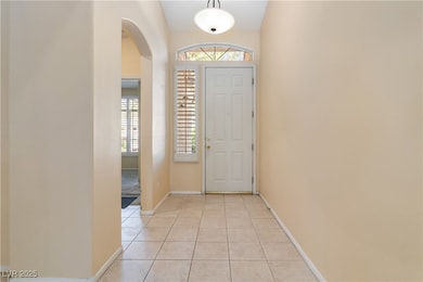 Entrance foyer with arched walkways, light tile pa