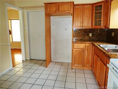 Kitchen looking in to living room and door to gara