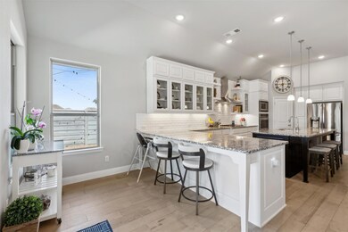 Kitchen with white cabinetry, appliances with stai