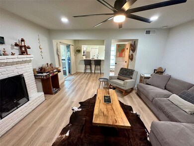 Living room featuring ceiling fan, a fireplace, b