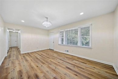 Unfurnished room with light hardwood / wood-style floors and an inviting chandelier