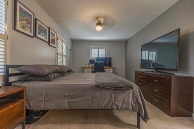Carpeted bedroom featuring ceiling fan