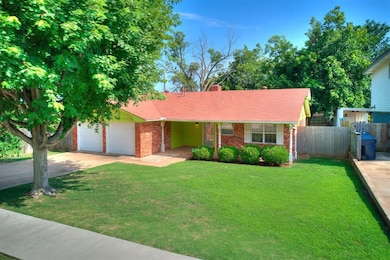View of front facade featuring a garage, concrete driveway, a chimney, brick siding, and roof with shingles