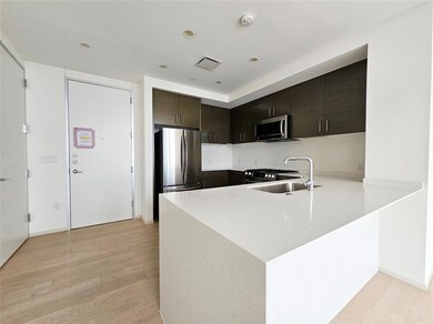 Kitchen featuring visible vents, a peninsula, lig