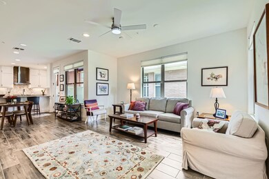 Living area featuring ceiling fan, light wood fin