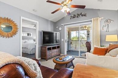 Carpeted living room featuring vaulted ceiling and