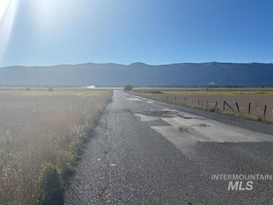 View of asphalt street with a view of rural / pastoral area and a mountain view