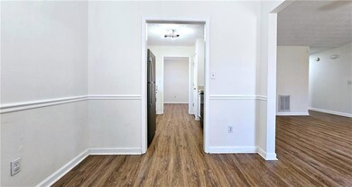Corridor with visible vents, baseboards, a texture