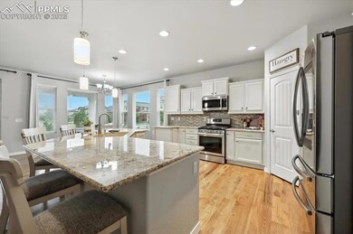 Kitchen with appliances with stainless steel finishes, tasteful backsplash, light wood-type flooring, recessed lighting, and a breakfast bar area