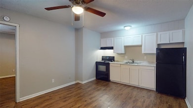 Kitchen featuring black appliances, dark wood-type