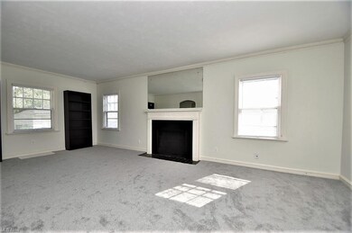 Spacious living room is graced by a fireplace