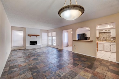 Unfurnished living room featuring a textured ceili