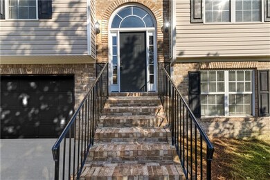Doorway to property featuring brick siding and an attached garage