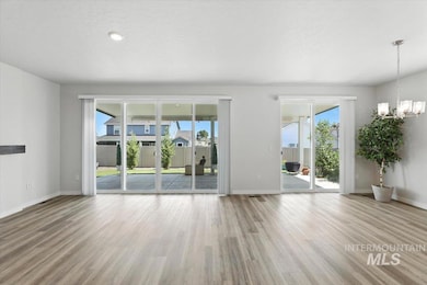 Spare room with wood finished floors and a chandelier