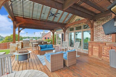 Wooden deck featuring a pergola, an outdoor kitche