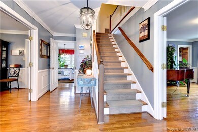 Stairway with an inviting chandelier, light hardwo