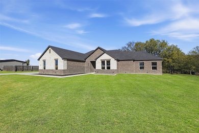 View of front of home with brick siding and roof with shingles
