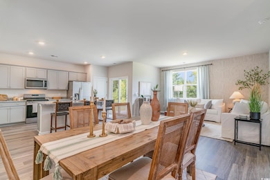 Dining area with light wood finished floors, recessed lighting, and wallpapered walls