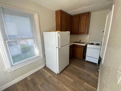 Kitchen with tasteful backsplash, white appliances, dark hardwood / wood-style floors, and sink