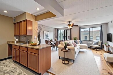 Kitchen featuring brown cabinetry, light stone counters, a peninsula, open floor plan, and recessed lighting
