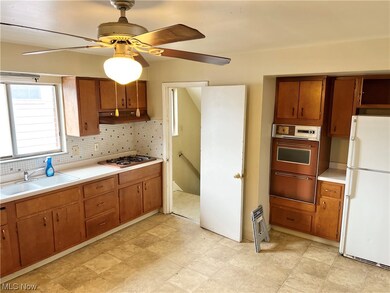 Huge Kitchen with vinyl flooring, white appliances, ceiling fan, sink, and tasteful backsplash