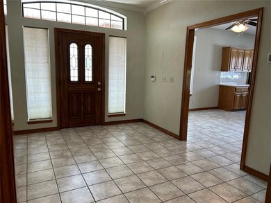 Tiled entryway featuring crown molding and ceiling