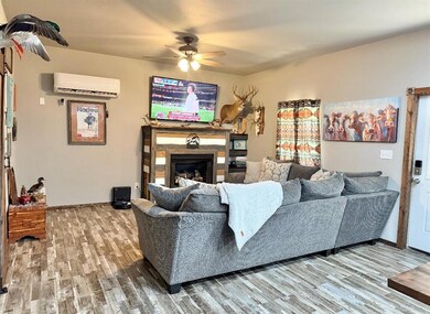 Living room featuring wood finished floors, a wall