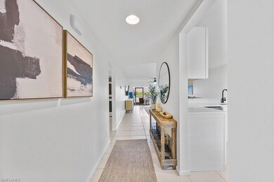 Corridor with light tile patterned flooring and ba