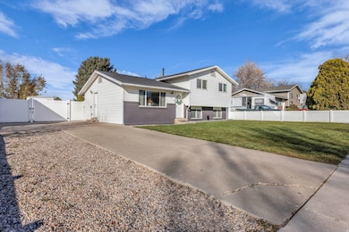 Rear view of house featuring a gate, brick siding, and driveway