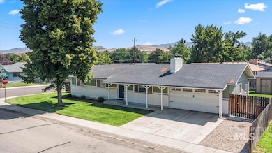 Ranch-style home featuring an attached garage, a mountain view, covered porch, and driveway