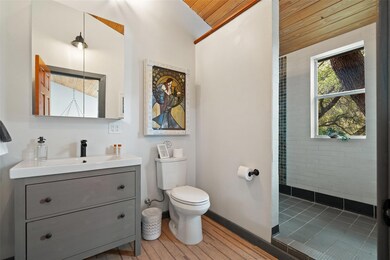 Bathroom with baseboards, tiled shower, toilet, w