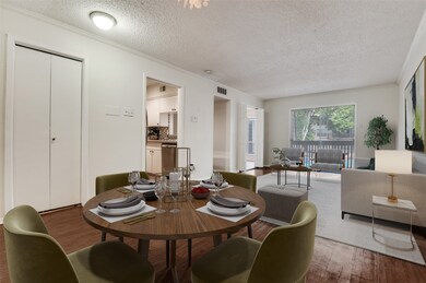 Dining space with ornamental molding, wood finished floors, and a textured ceiling